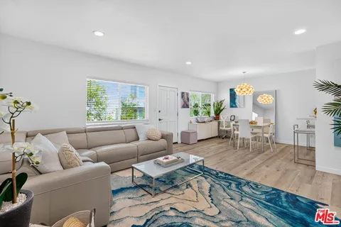 a living room with furniture wooden floor and a large window