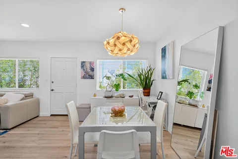 a dining room with furniture potted plants and wooden floor