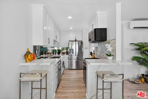 a kitchen that has a lot of cabinets and wooden floor