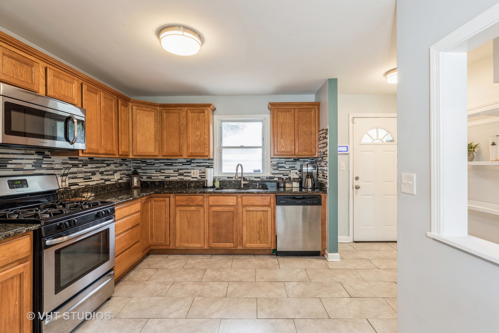 1469 Burr Oak Road Homewood, IL 60430 - Photo 7 of 24 a kitchen with stainless steel appliances granite countertop a stove a sink and a microwave