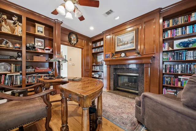 a living room with fireplace furniture and a book shelf