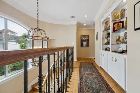 a view of a hallway with wooden floor and windows