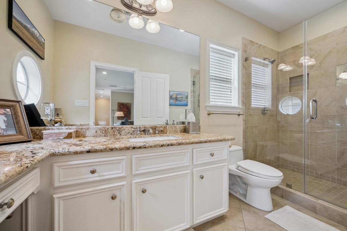 2309 Shakespeare Street Houston, TX 77030 - Photo 29 of 48 a bathroom with a granite countertop sink a toilet a mirror and shower