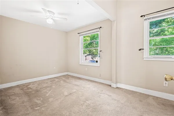 an empty room with windows and fan
