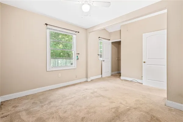 an empty room with windows and closet