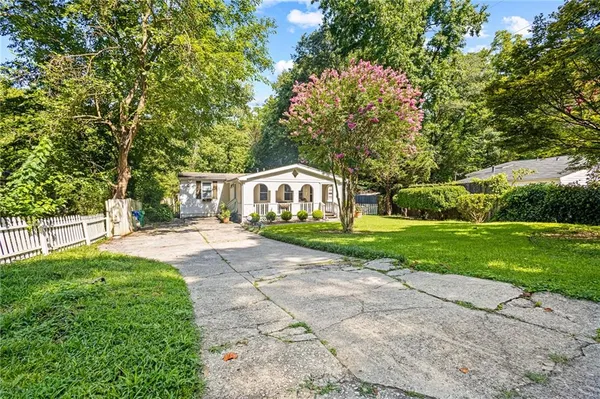 a front view of a house with yard and green space