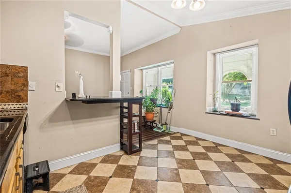 a room with a black white checkered floor with a gaming machine and a rug