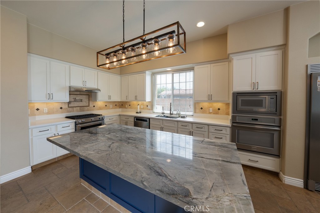 125 West Franklin Avenue Ridgecrest, CA 93555 - Photo 17 of 32 a kitchen with stainless steel appliances granite countertop a sink a stove top oven a counter space and cabinets