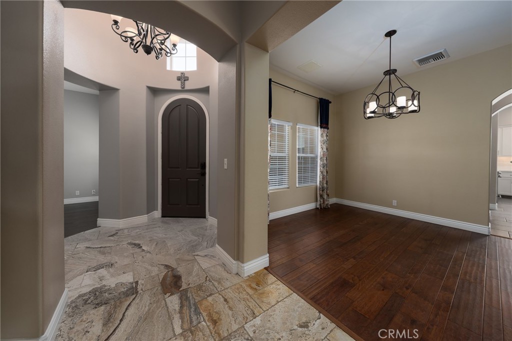 125 West Franklin Avenue Ridgecrest, CA 93555 - Photo 7 of 32 an empty room with wooden floor chandelier and windows