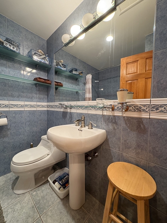 140 Kenrick Street, Unit 21 Boston, MA 02135 - Photo 17 of 36 a bathroom with a sink a toilet and a mirror