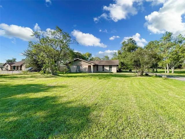 a house view with swimming pool and trees in the background