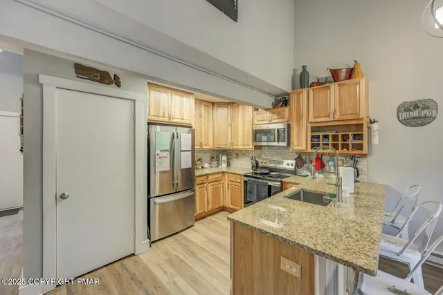 a kitchen with stainless steel appliances granite countertop a refrigerator and a sink