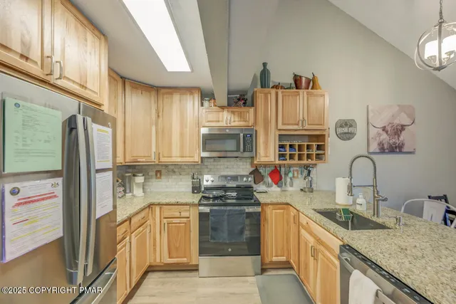 a kitchen with stainless steel appliances granite countertop a sink stove and refrigerator