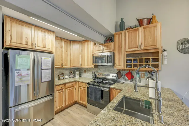 a kitchen with stainless steel appliances granite countertop a stove and a refrigerator