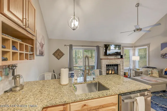 a kitchen with a stove a sink a dining table and chairs with wooden floor