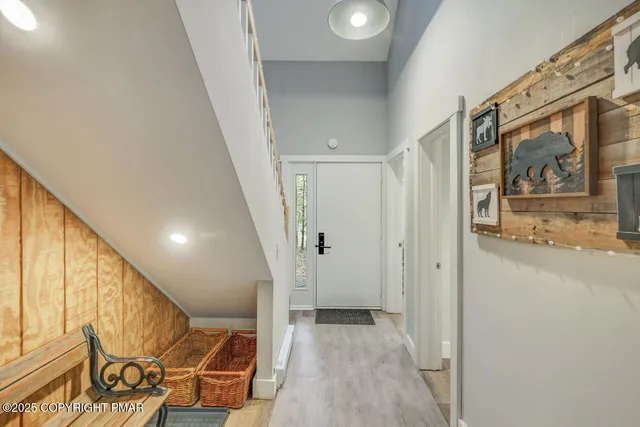 a view of a hallway with wooden floor and staircase