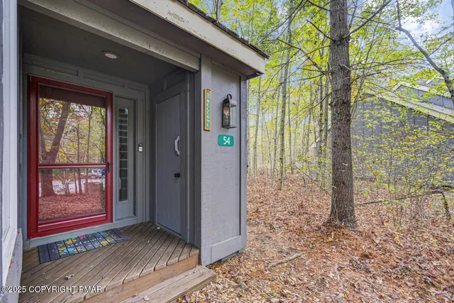 a view of a brick house with a large tree