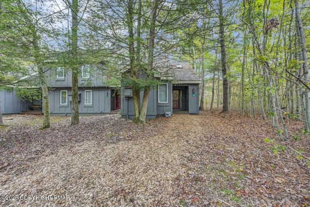 a view of a wooden chairs and table in a backyard