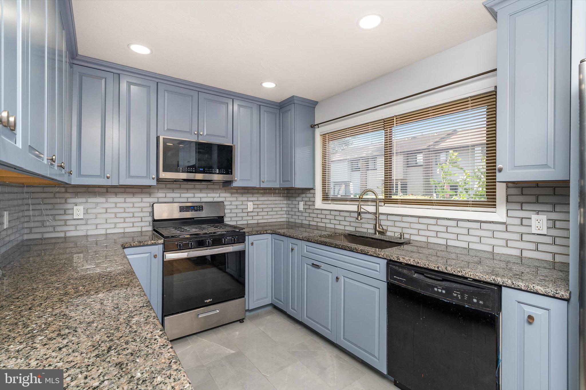 234 Probasco Road East Windsor, NJ 08520 - Photo 10 of 25 a kitchen with stainless steel appliances granite countertop a sink stove microwave and view of living room