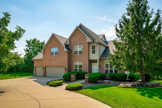 a front view of a house with a yard and trees