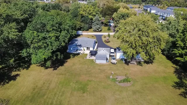 an aerial view of a house with yard swimming pool and lake view