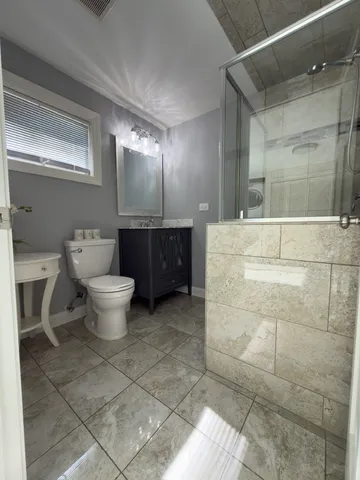a large bathroom with toilet sink and mirror