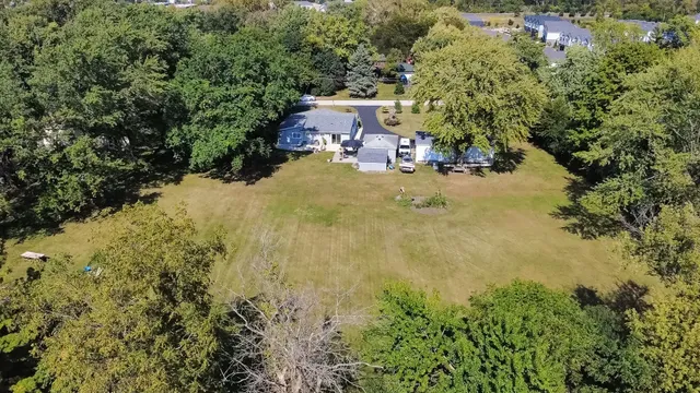 an aerial view of residential house with space and trees all around