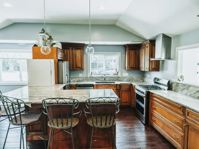 a kitchen with stainless steel appliances granite countertop wooden cabinets a stove top oven a sink and dishwasher