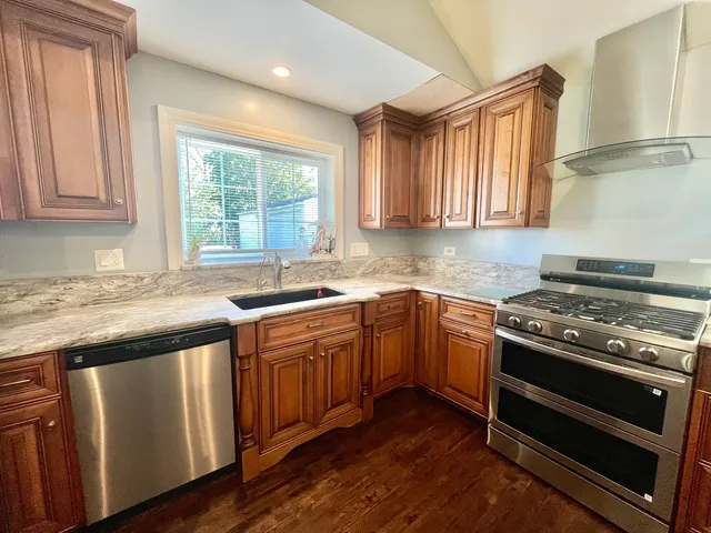 a kitchen with granite countertop wooden cabinets and a sink