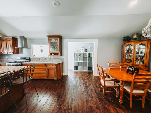 a kitchen with stainless steel appliances granite countertop wooden floors and table