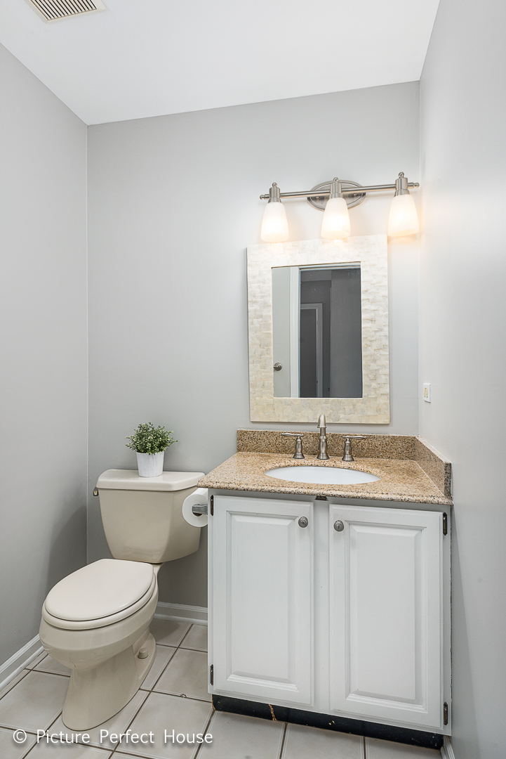 1235 Leverenz Road Naperville, IL 60564 - Photo 11 of 25 a bathroom with a granite countertop toilet a sink and a mirror