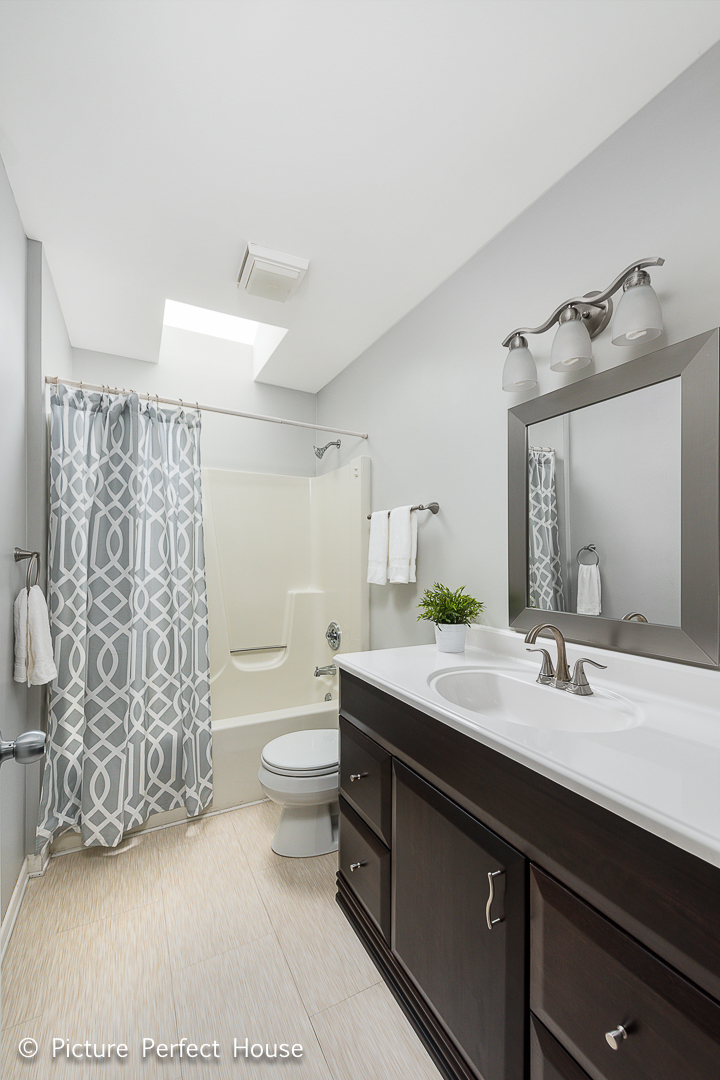 1235 Leverenz Road Naperville, IL 60564 - Photo 17 of 25 a bathroom with a double vanity sink toilet and shower