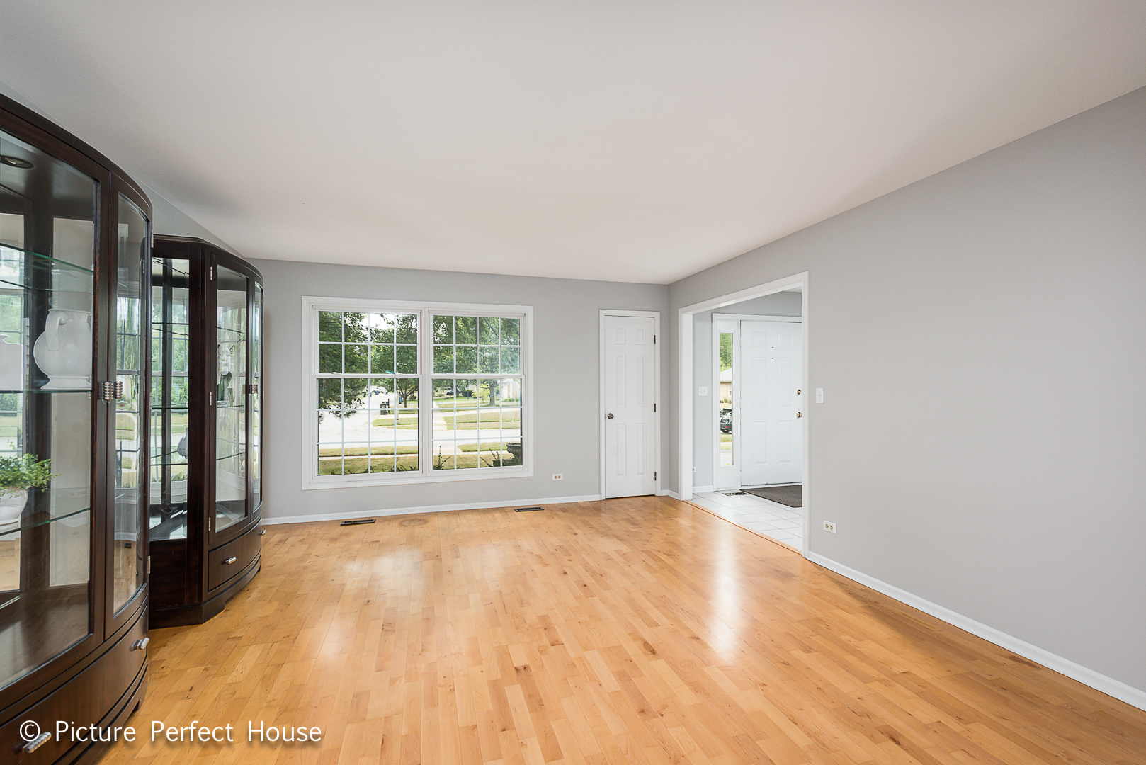 1235 Leverenz Road Naperville, IL 60564 - Photo 7 of 25 a view of an empty room with a window and wooden floor