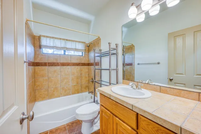 a bathroom with a sink a toilet a mirror and shower