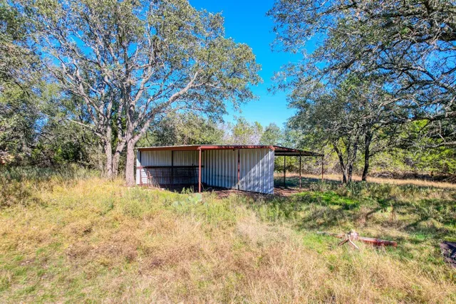 a house is sitting in middle of the forest