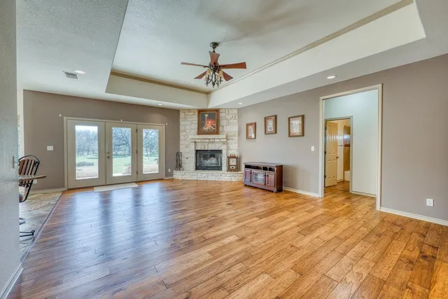 a view of an empty room with window and wooden floor