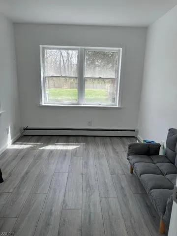a living room with a wooden floor and a window