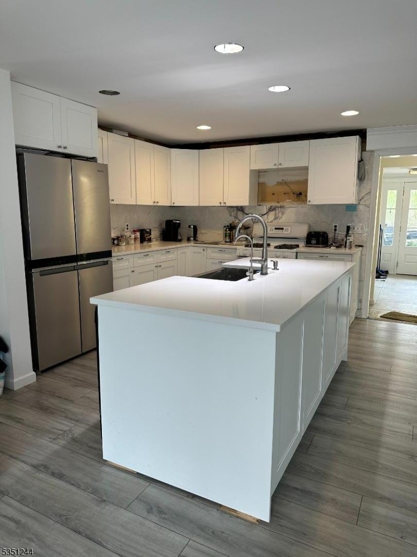 213 Liberty Corner Road Bernards, NJ 07931 - Photo 5 of 24 a kitchen with stainless steel appliances a refrigerator a sink a stove top oven a wooden floor and cabinets