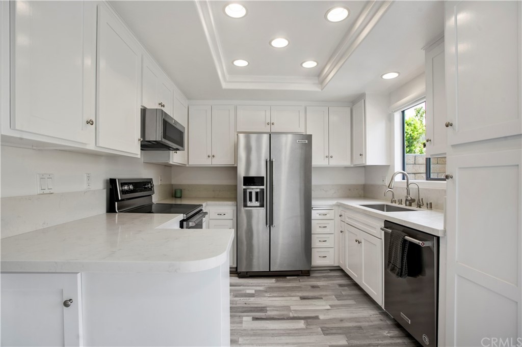 3 Blue Lagoon Laguna Beach, CA 92651 - Photo 4 of 32 a kitchen with stainless steel appliances a refrigerator sink and white cabinets