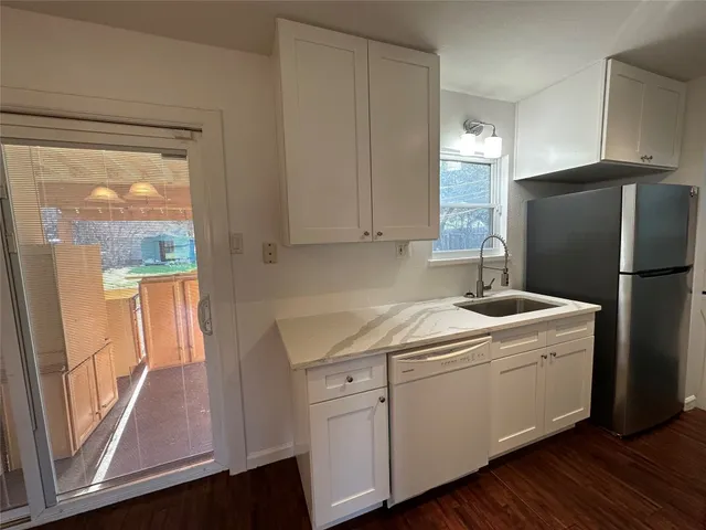 a kitchen with a refrigerator sink and cabinets