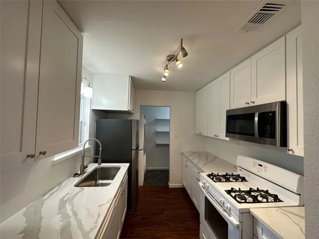 a kitchen with stainless steel appliances a stove a microwave and a refrigerator