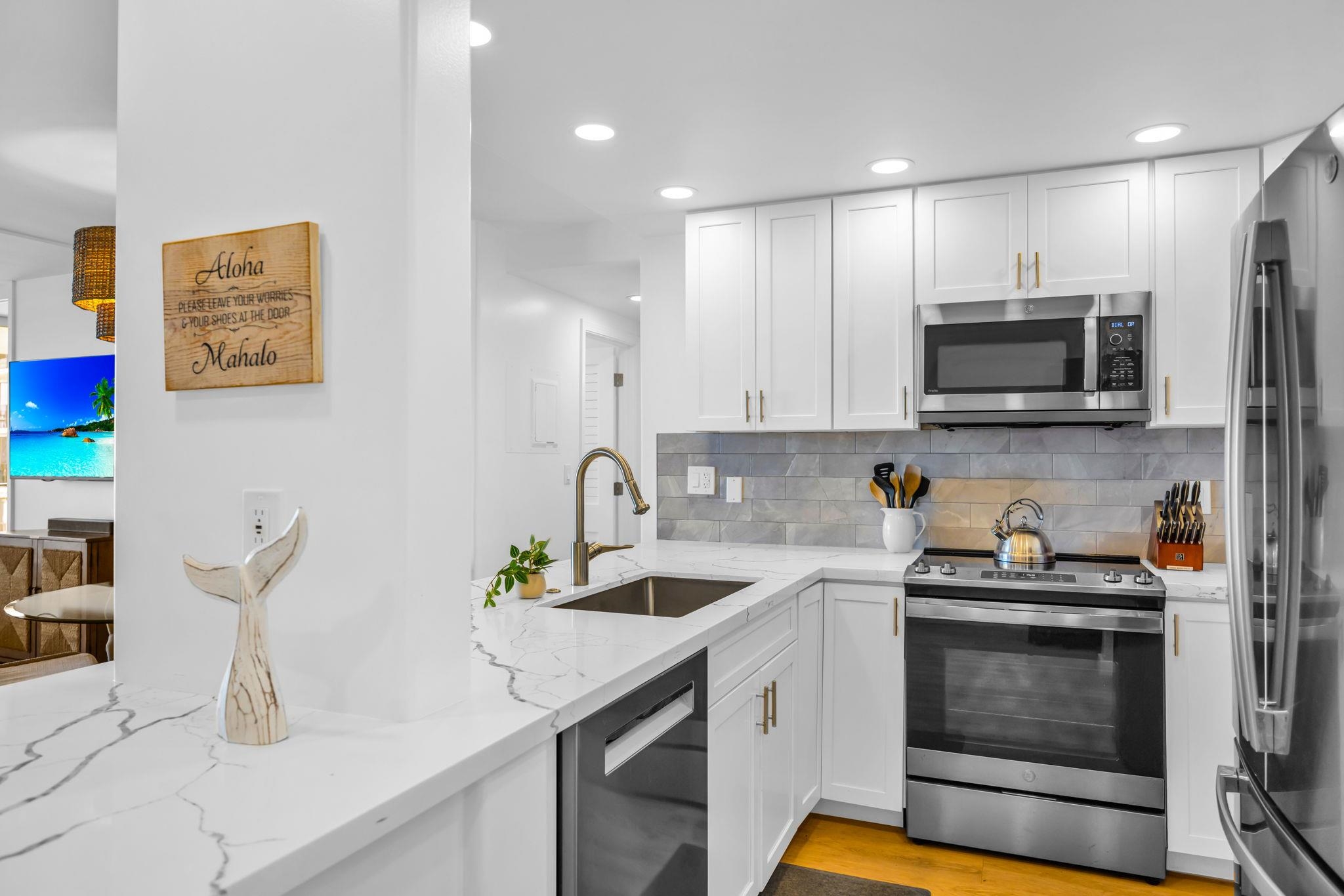 4401 Lower Honoapiilani Road, Unit B603 Lahaina, HI 96761 - Photo 13 of 41 a kitchen with granite countertop a sink and a stove top oven