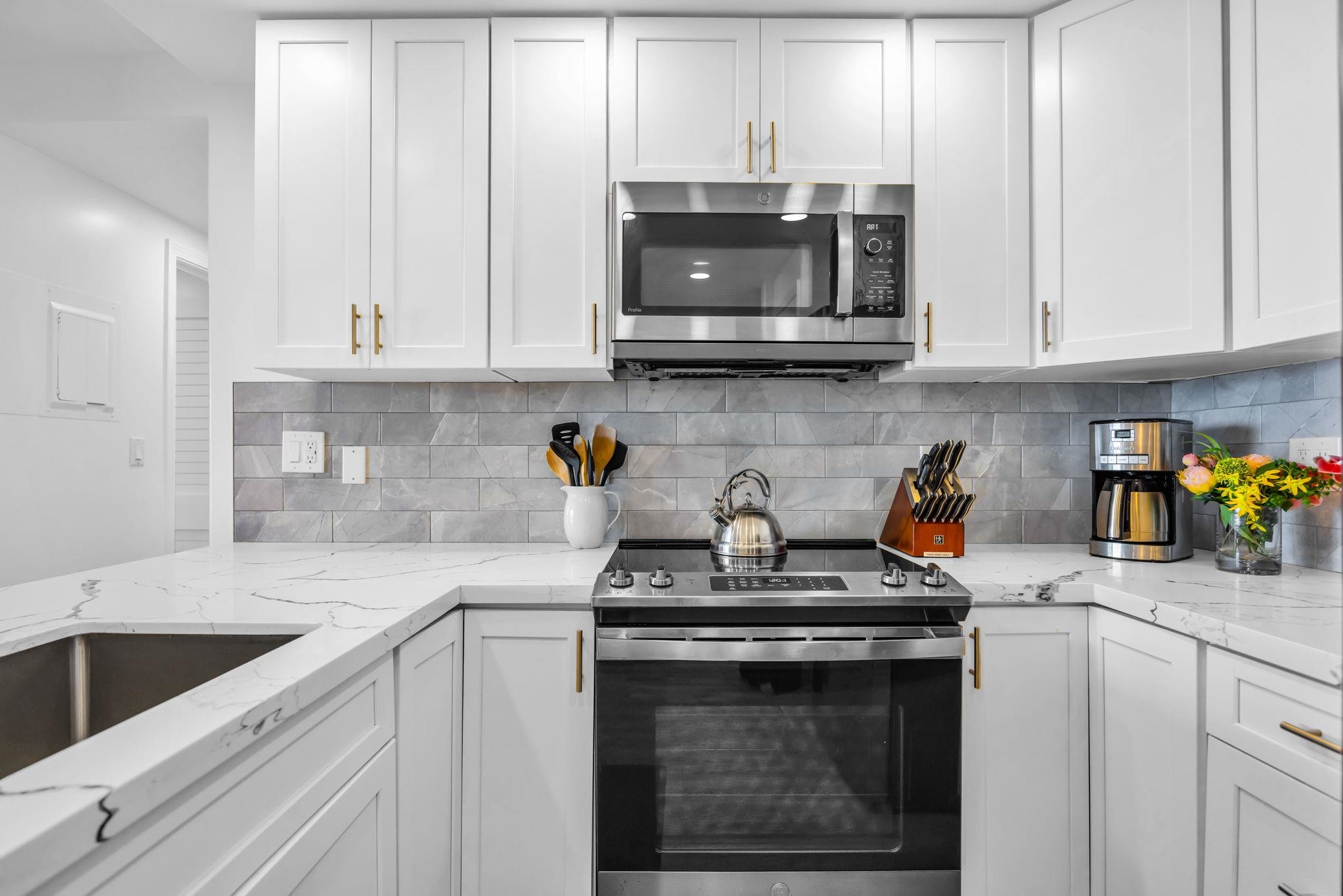 4401 Lower Honoapiilani Road, Unit B603 Lahaina, HI 96761 - Photo 15 of 41 a kitchen with stainless steel appliances granite countertop white cabinets a stove a sink and a white appliances