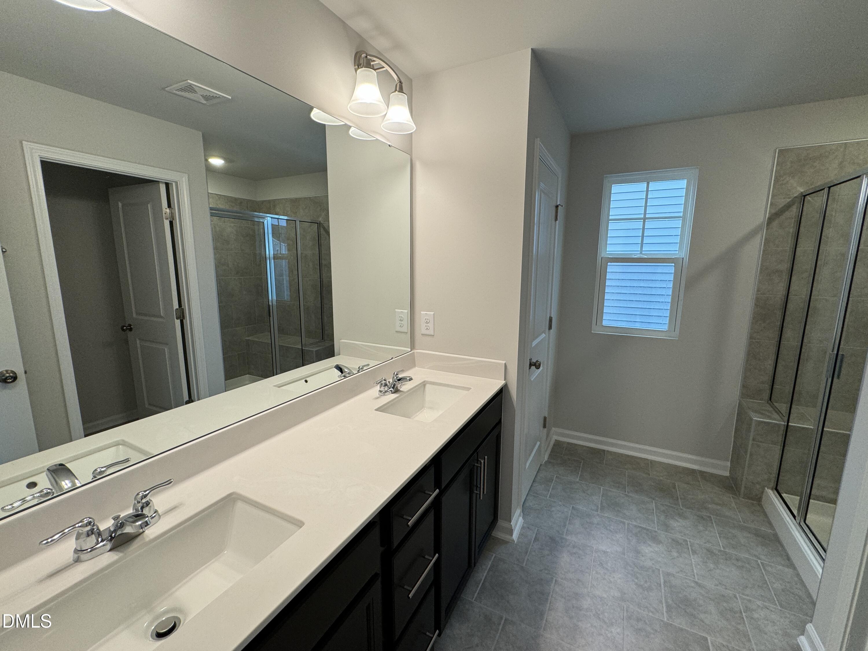 5706 Woodlawn Drive Durham, NC 27703 - Photo 18 of 20 a bathroom with a double vanity sink a and mirror