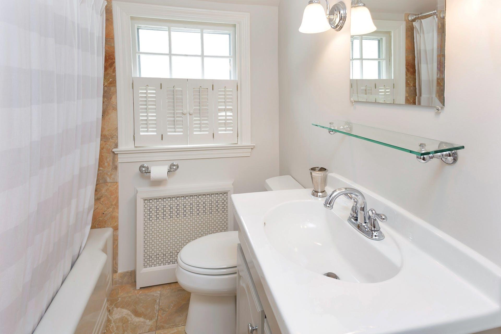 45 Relihan Road Darien, CT 06820 - Photo 22 of 28 a bathroom with a sink a toilet and a mirror