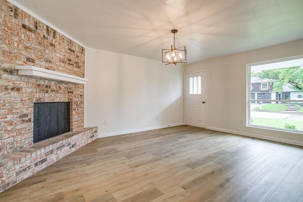 713 Vaughn Drive Burleson, TX 76028 - Photo 12 of 40 an empty room with wooden floor fireplace and windows