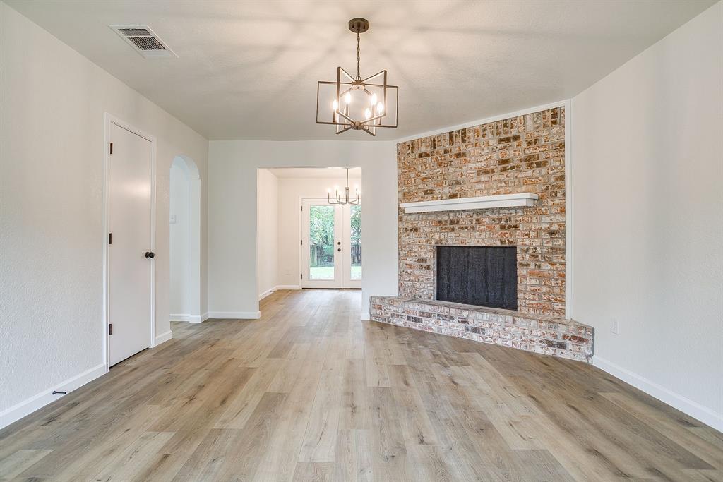 713 Vaughn Drive Burleson, TX 76028 - Photo 14 of 40 a view of an empty room with wooden floor fireplace and a window