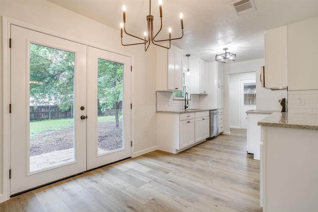713 Vaughn Drive Burleson, TX 76028 - Photo 15 of 40 a large kitchen with cabinets a sink and a wooden floor