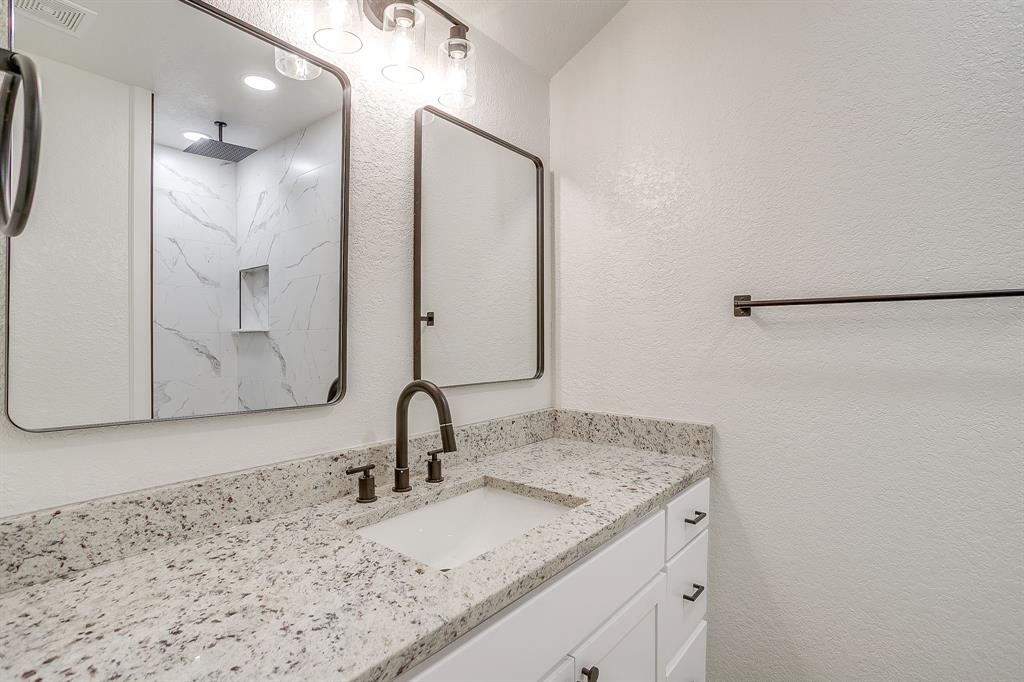 713 Vaughn Drive Burleson, TX 76028 - Photo 33 of 40 a bathroom with a granite countertop sink and a mirror