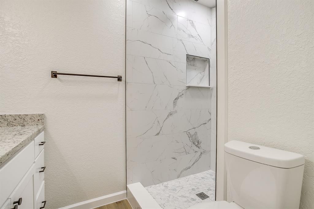 713 Vaughn Drive Burleson, TX 76028 - Photo 34 of 40 a bathroom with a granite countertop sink toilet and shower